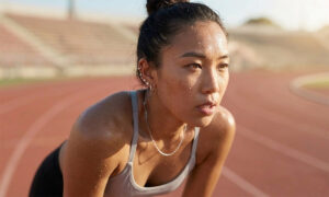Runner drenched in sweat on a track after a hard effort