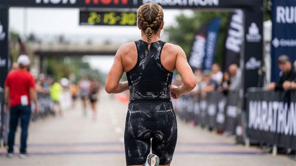 Runner with visible white salt crust on their shirt and hat after a hot race, a classic sign of a heavy, salty sweater
