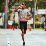 Endurance athlete drinking from a sports bottle mid-race, illustrating sodium intake during a race