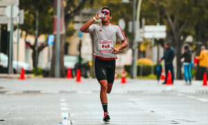 Endurance athlete drinking from a sports bottle mid-race, illustrating sodium intake during a race