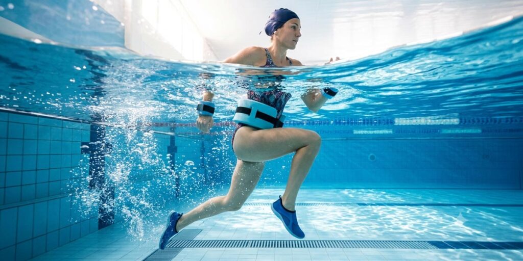 a woman inside a swimming pool practicing aqua jogging