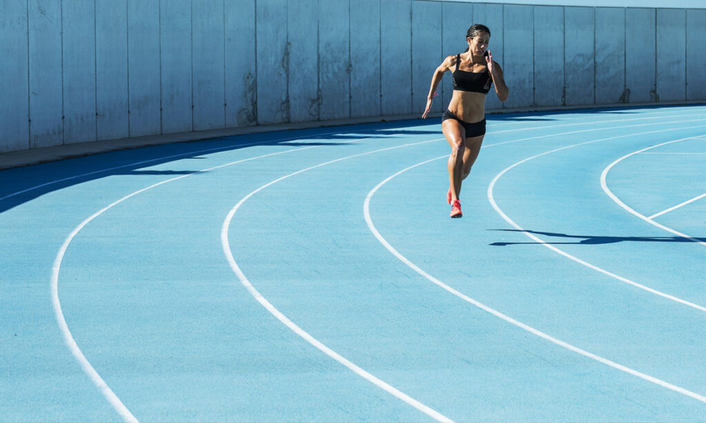 Runner holding a steady, controlled effort on a track during a tempo vs threshold training run
