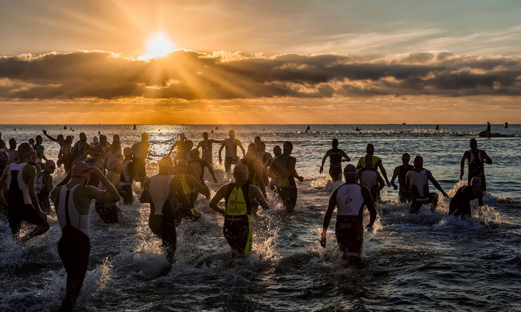 triathletes entering the water in a triathlon