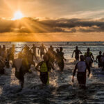 triathletes entering the water in a triathlon