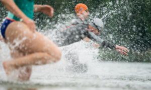 triathletes entering water at the beginning of a olympic triathlon