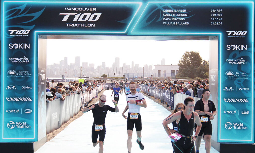 age-group triathletes crossing the finish line in the T100 Vancouver Olympic distance